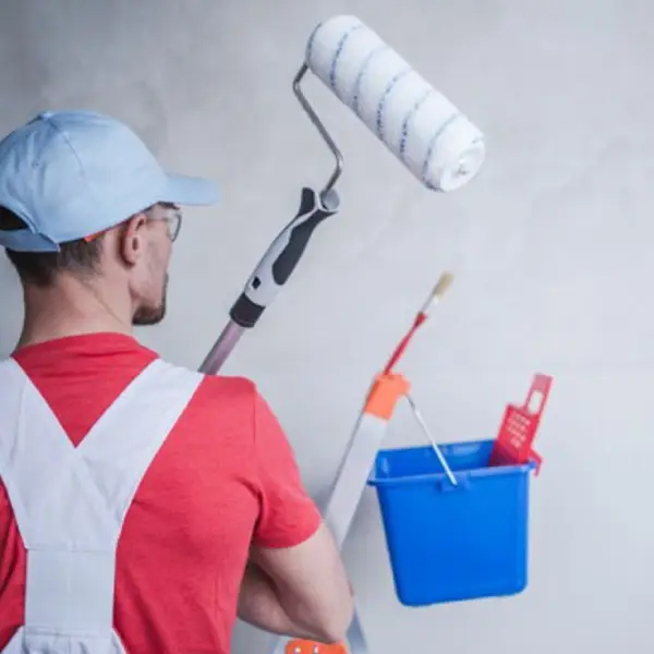 a man holding painting tools